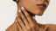 Close-up of a woman’s hand gently touching her face, showcasing a glossy nude-pink gel manicure with square-shaped nails against a soft, neutral background | 14 Day Mani