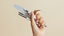 hand holding manicure tools like files, cuticle nippers, and cuticle pushers against a neutral beige background