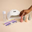 Nail care products including a lamp, nail polish bottles, and tools on a beige background