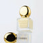 Nail gloss bottle with gold cap on a light gray background