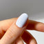 Hand with a light blue nail polish on a neutral background