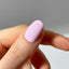 Close-up of a hand with a lilac nail on a neutral background